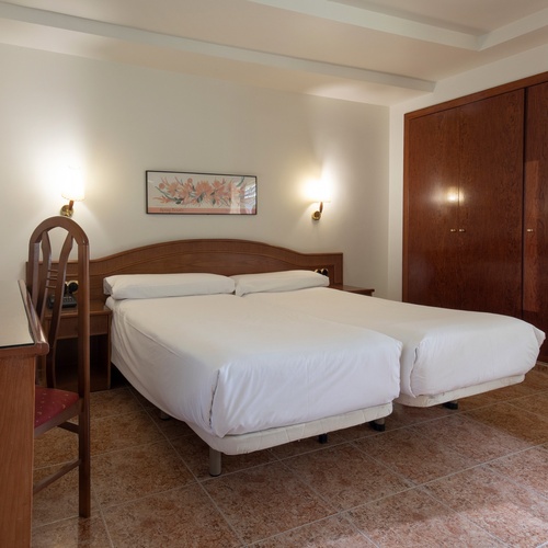 una habitación de hotel con dos camas y un escritorio