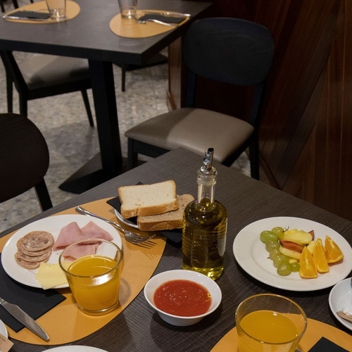 a table with plates of food and a bottle of olive oil
