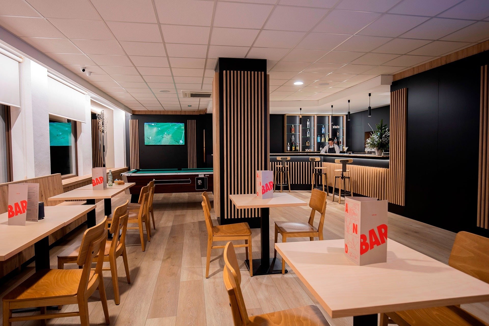 a bar with tables and chairs and a pool table