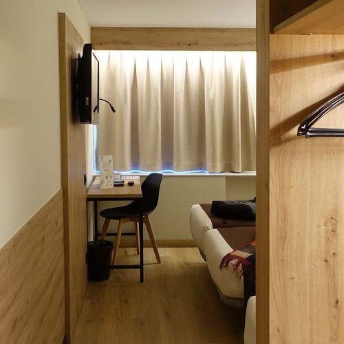 a hotel room with a desk and a chair