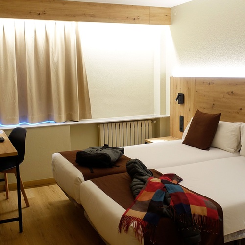 una habitació d' hotel amb dues camas i una televisió