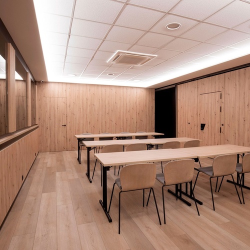 une salle de classe avec des tables et des chaises en bois