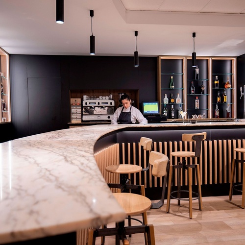 une salle de classe avec des tables et des chaises et un panneau qui dit hotel comptes