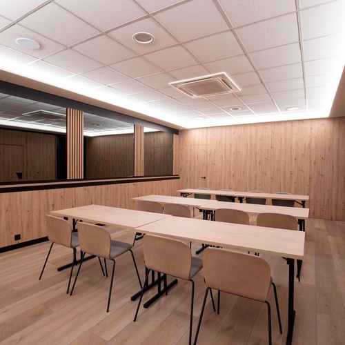 une salle de classe avec des tables et des chaises en bois