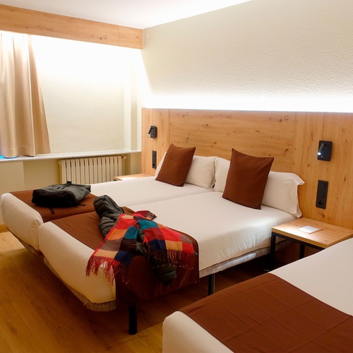 una habitación de hotel con dos camas y una mesa