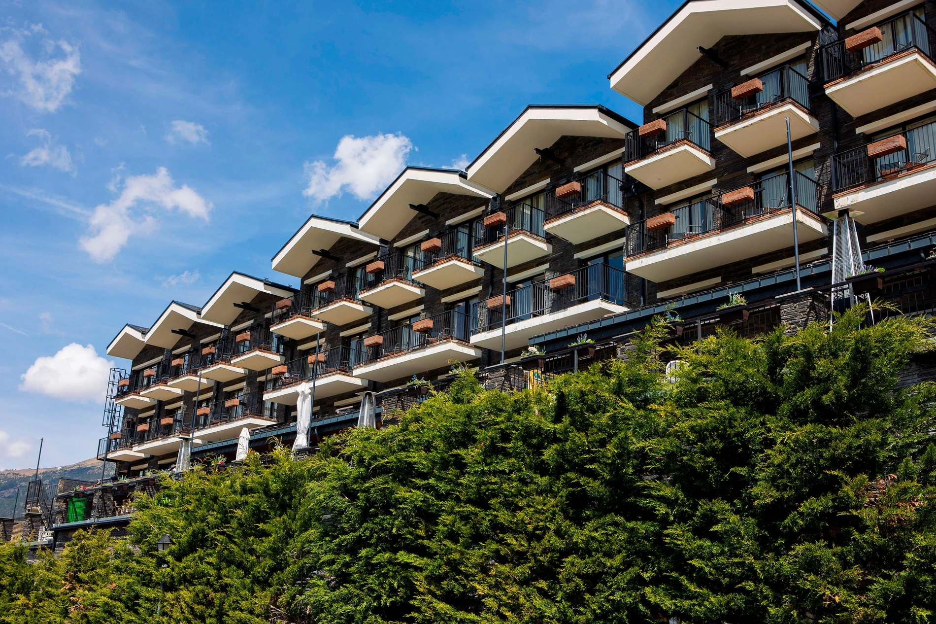Hotel Piolets Soldeu Centre: balcons moderns amb vistes al cel blau.