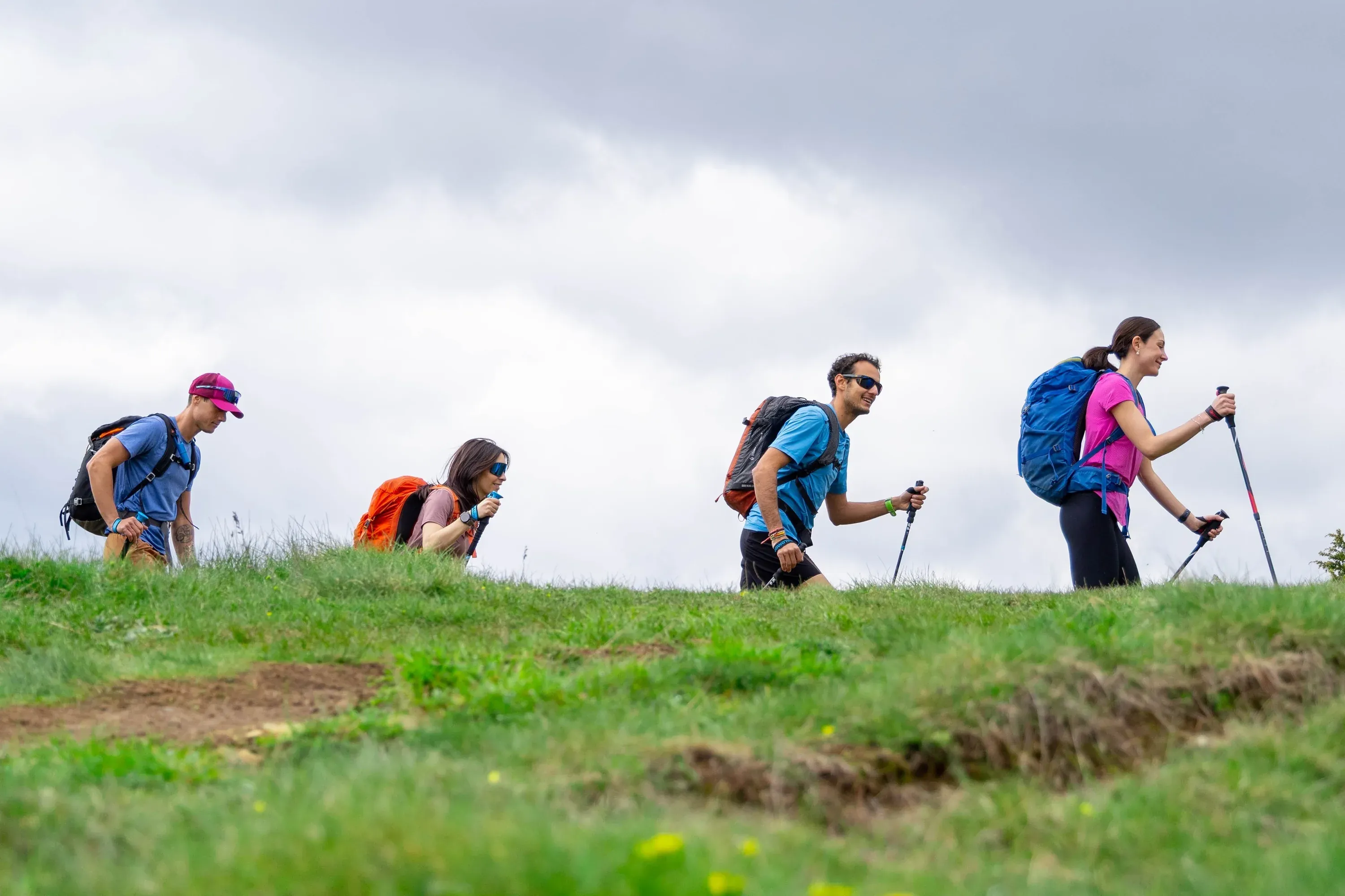 Hikers with backpacks on green hill, perfect for NEXTA: Corporativa retreats.