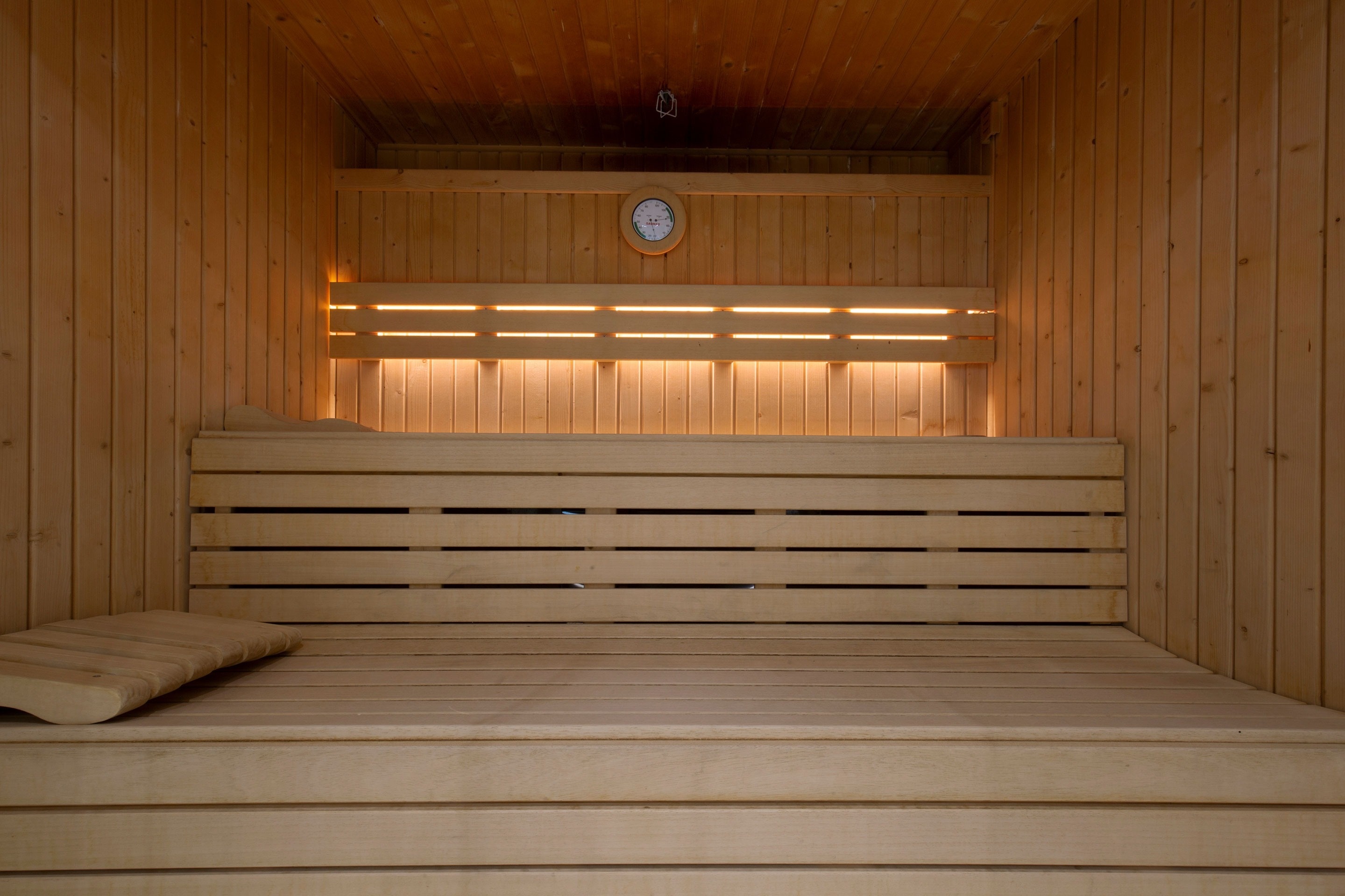 a wooden sauna with a clock on the wall