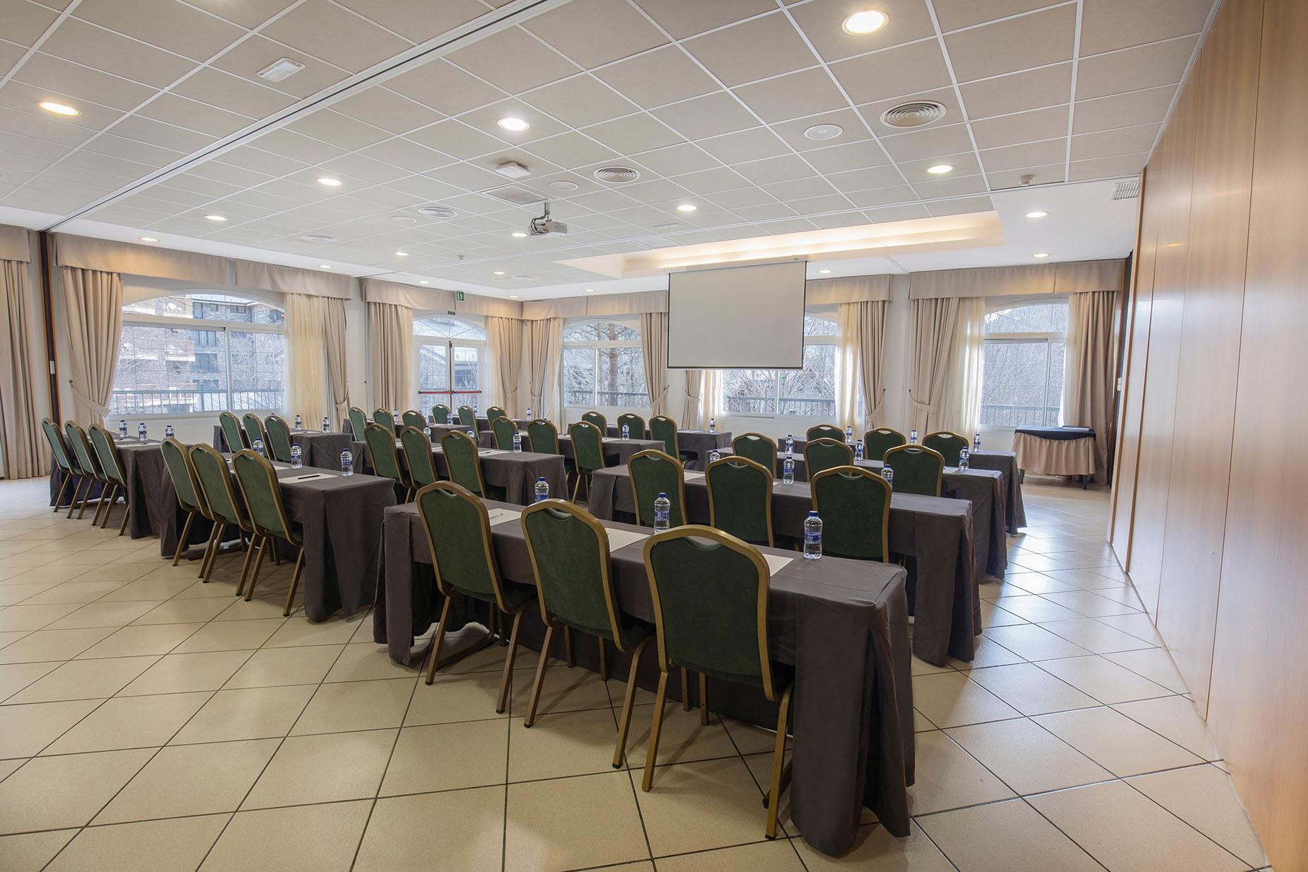 Sala de conferencias con mesas y sillas, ideal para tu próximo NEXTA: Corporativa.