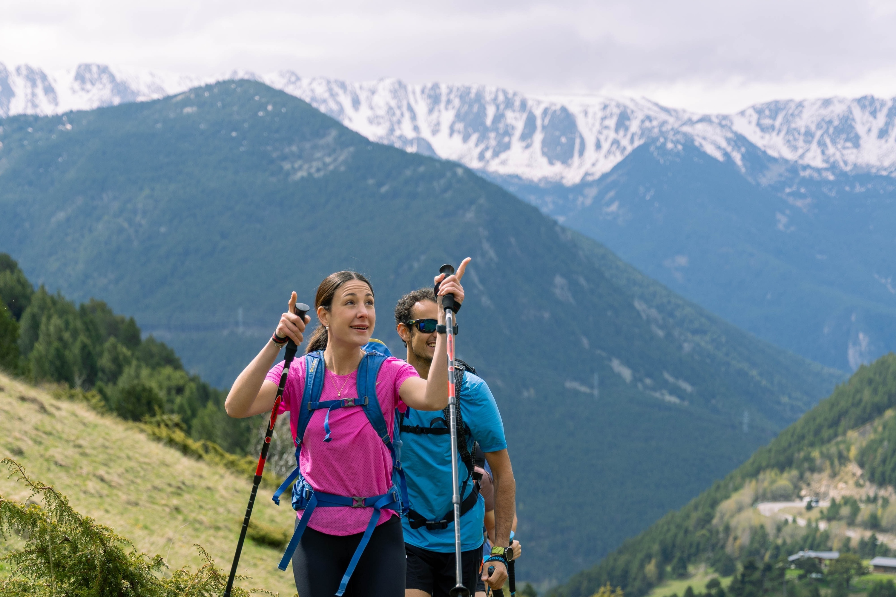 a man and a woman hiking up a hill holding hands