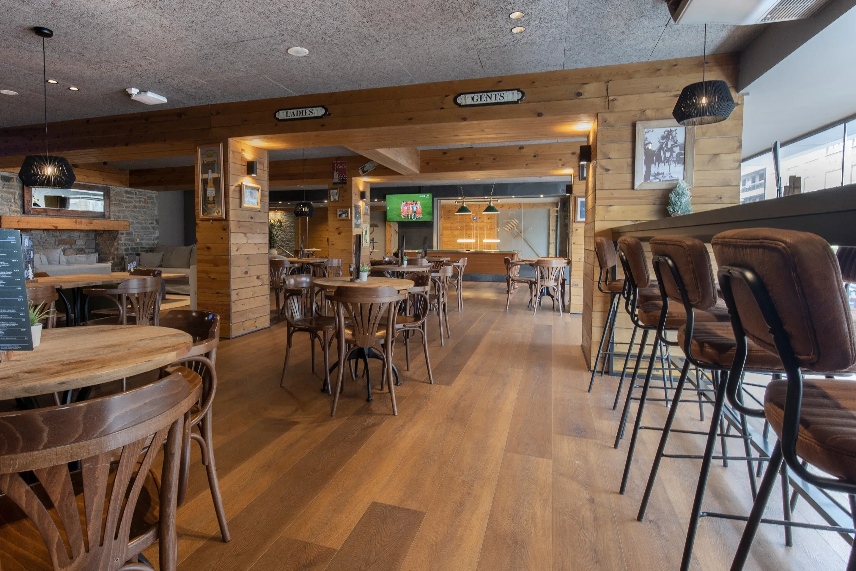 Bar del hotel NEXTA: Corporativa con mesas de madera, sillas y taburetes de cuero.