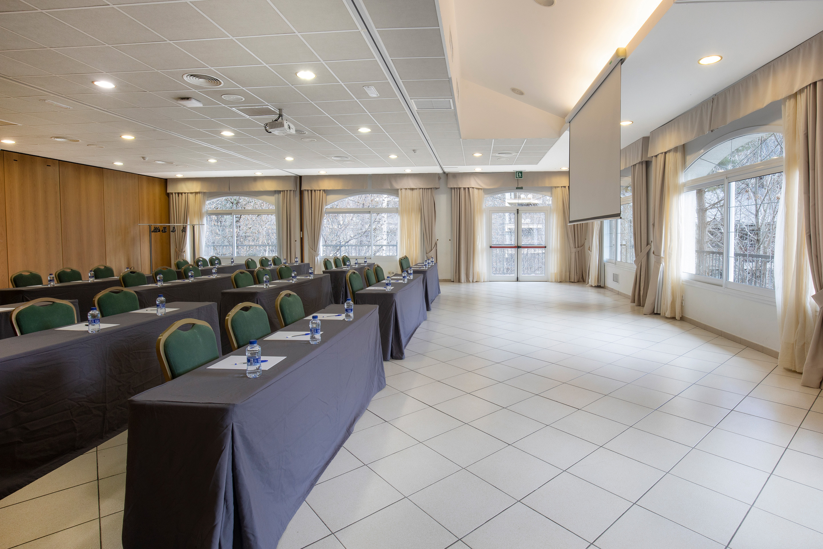 Sala de conferencias con mesas, sillas y NEXTA: Corporativa, ideal para eventos corporativos.