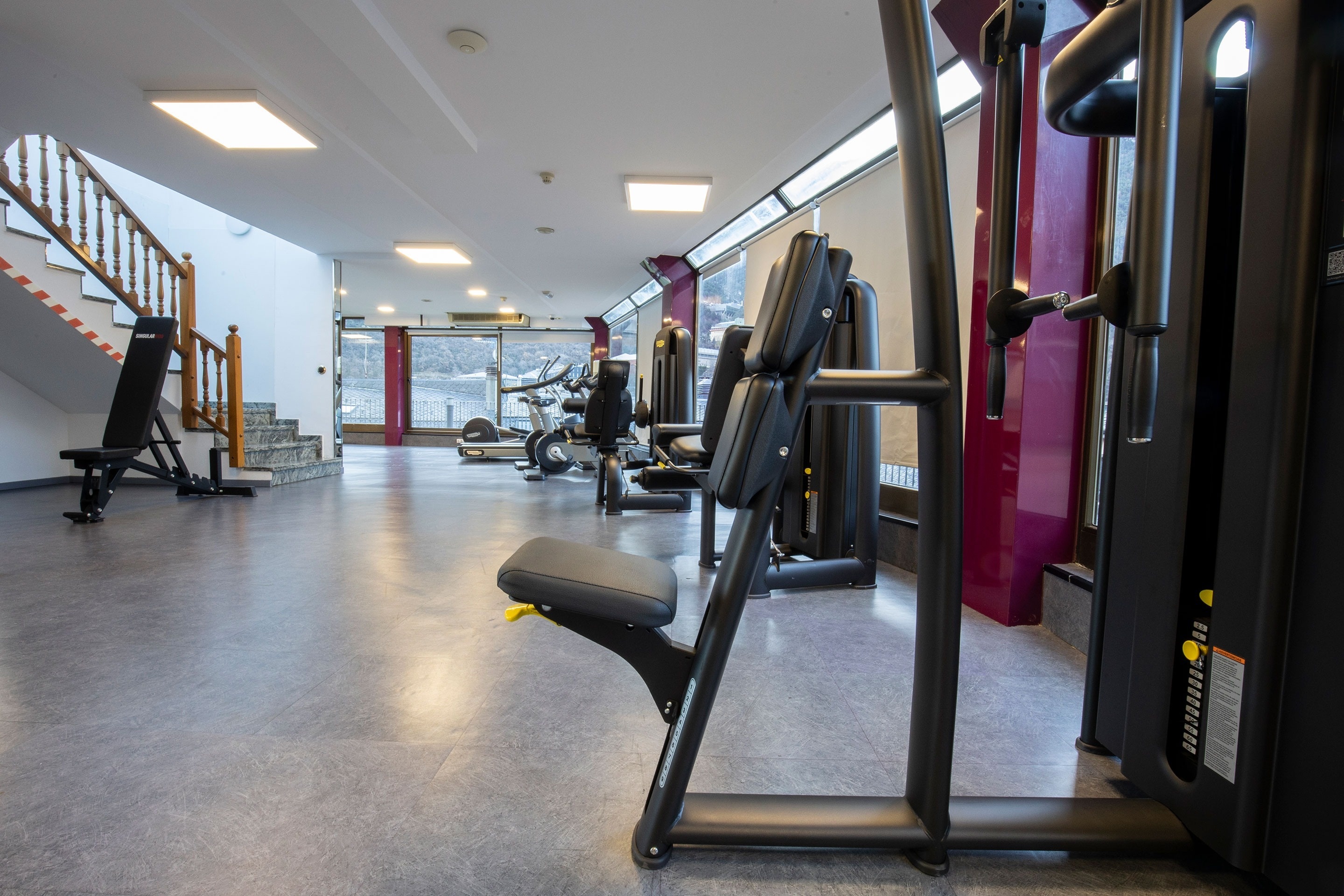 una sala de gimnasia llena de maquinaria y escaleras