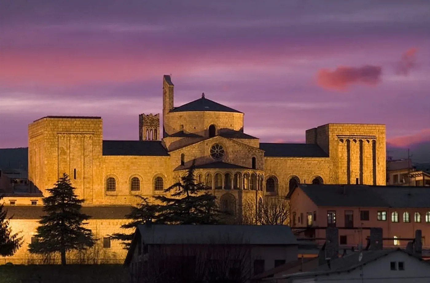 Hôtel NEXTA: Corporatif, basilique majestueuse devant un coucher de soleil violet.