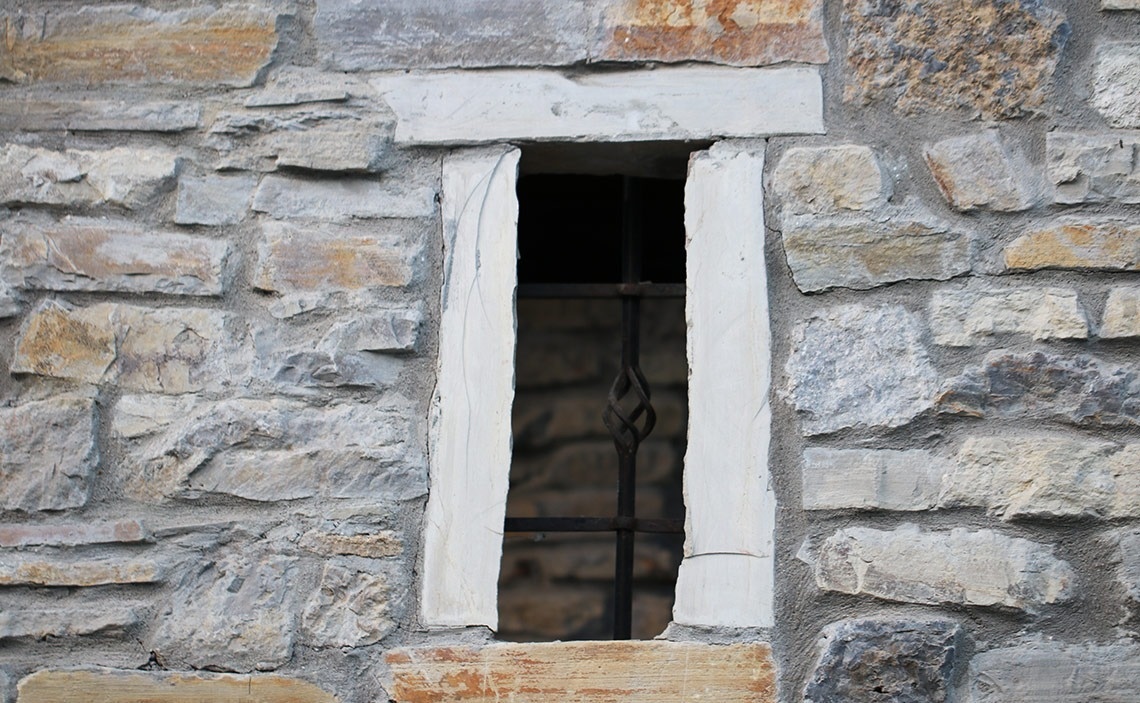 une fenêtre dans un mur en pierre avec un cadre blanc