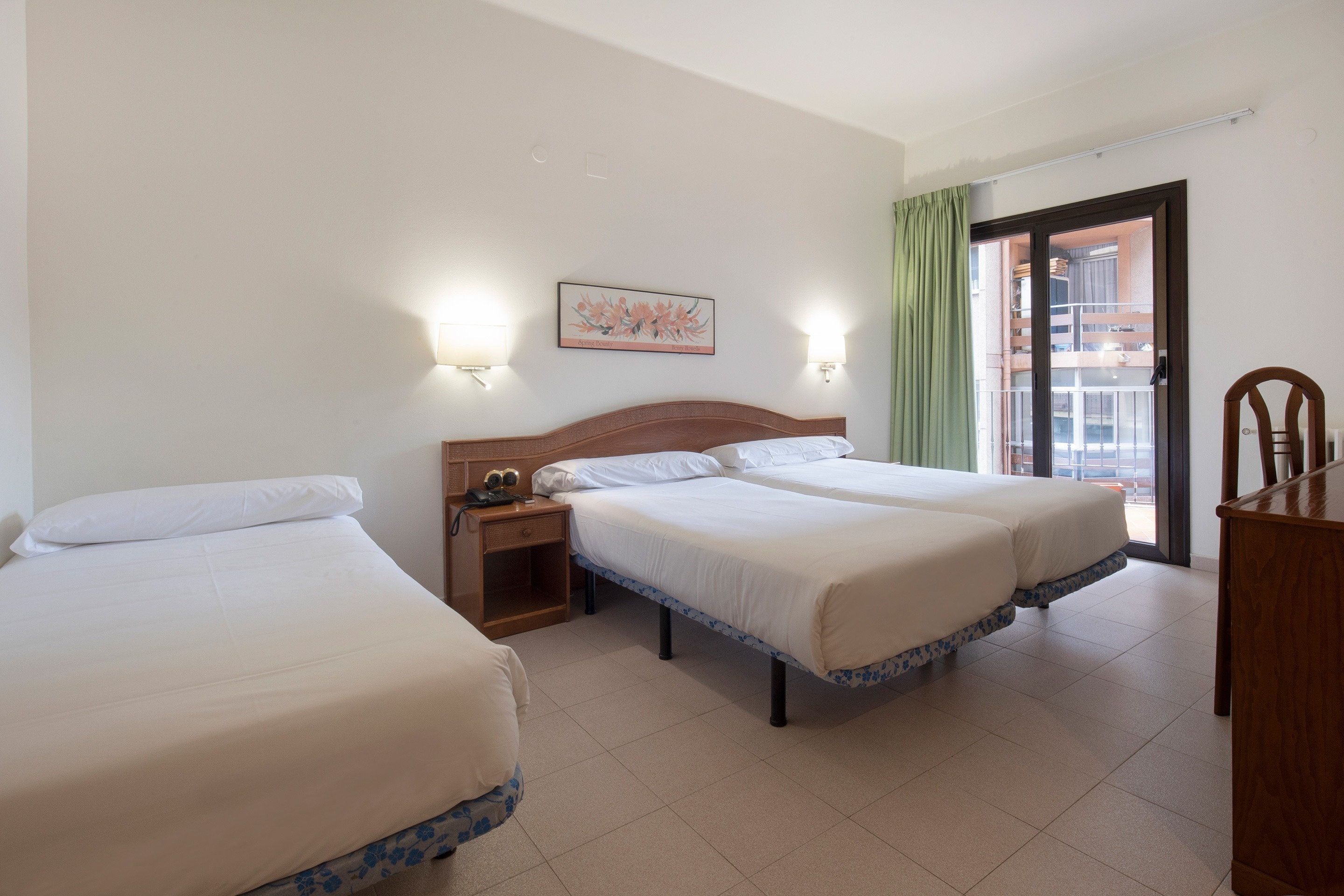 a hotel room with three beds and a picture on the wall