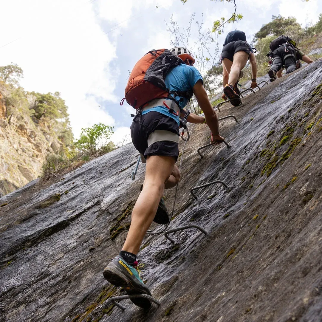 NEXTA: Corporate. Adventurers on a via ferrata, climbing rock with mountain gear.