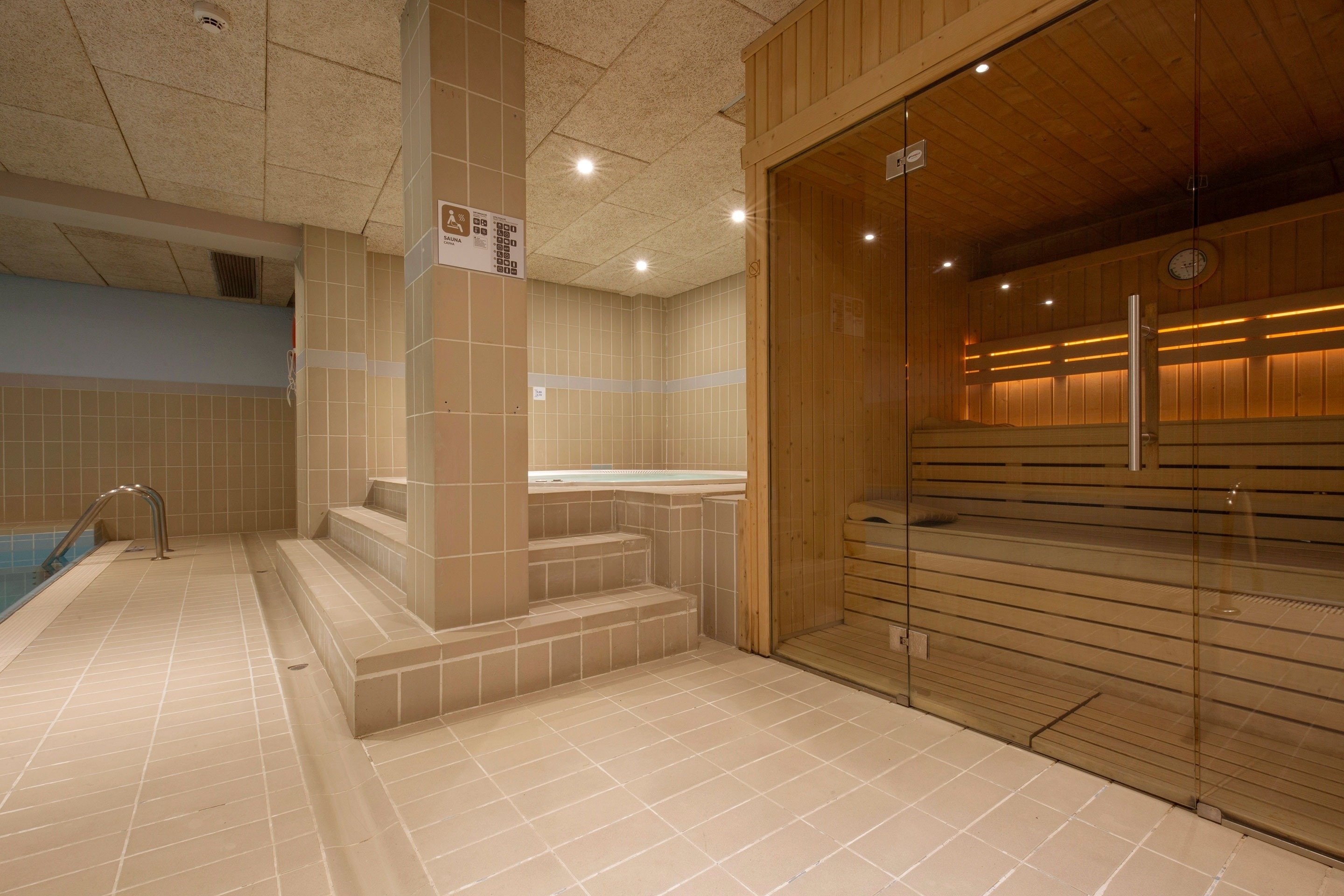 une salle de bain avec un sauna et une piscine