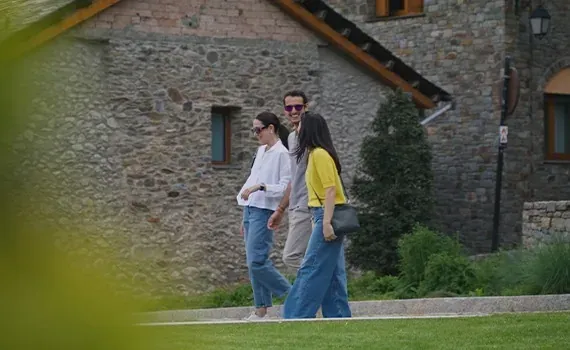 a woman leaning on a railing looking at her phone