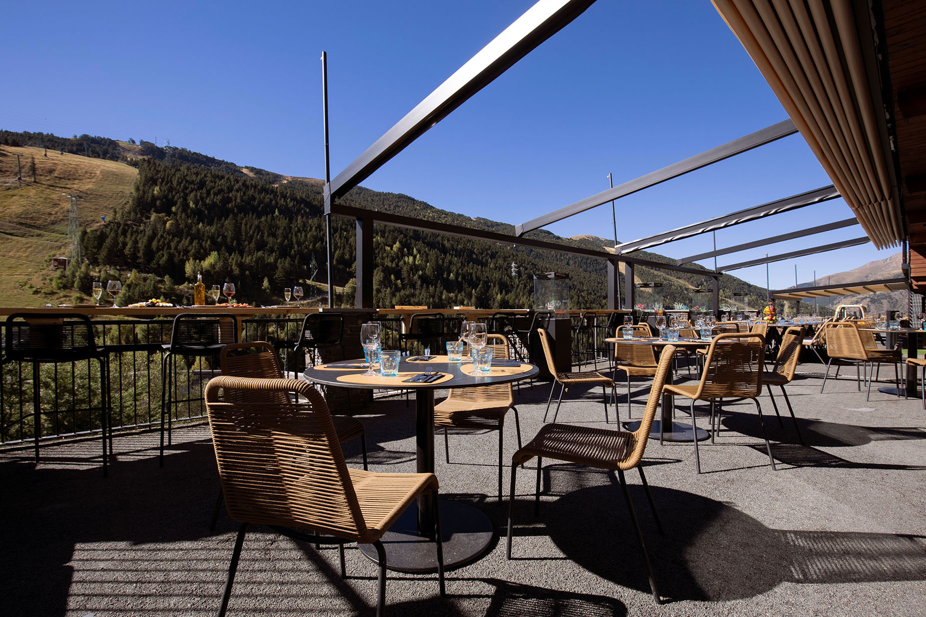 Terraza de hotel NEXTA: Corporativa con vistas a la montaña y mesas listas para cenar.