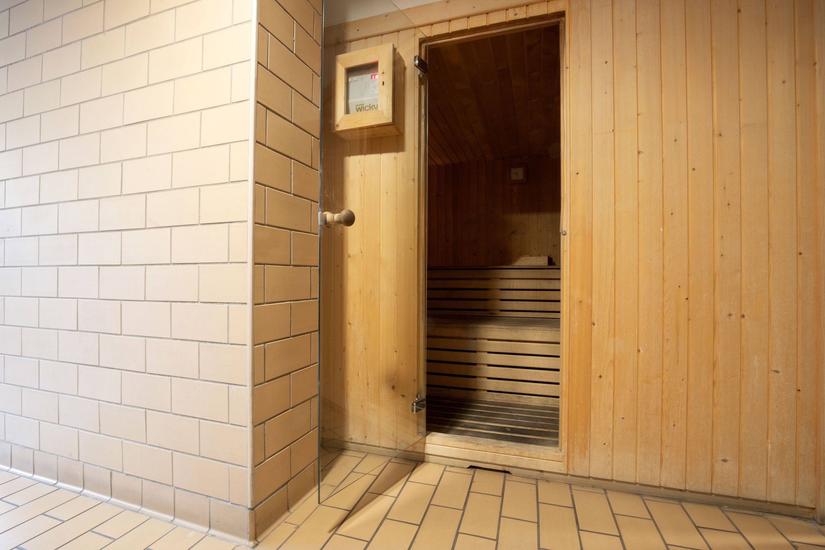 un sauna en bois avec une porte ouverte et une boîte à outils à l' intérieur