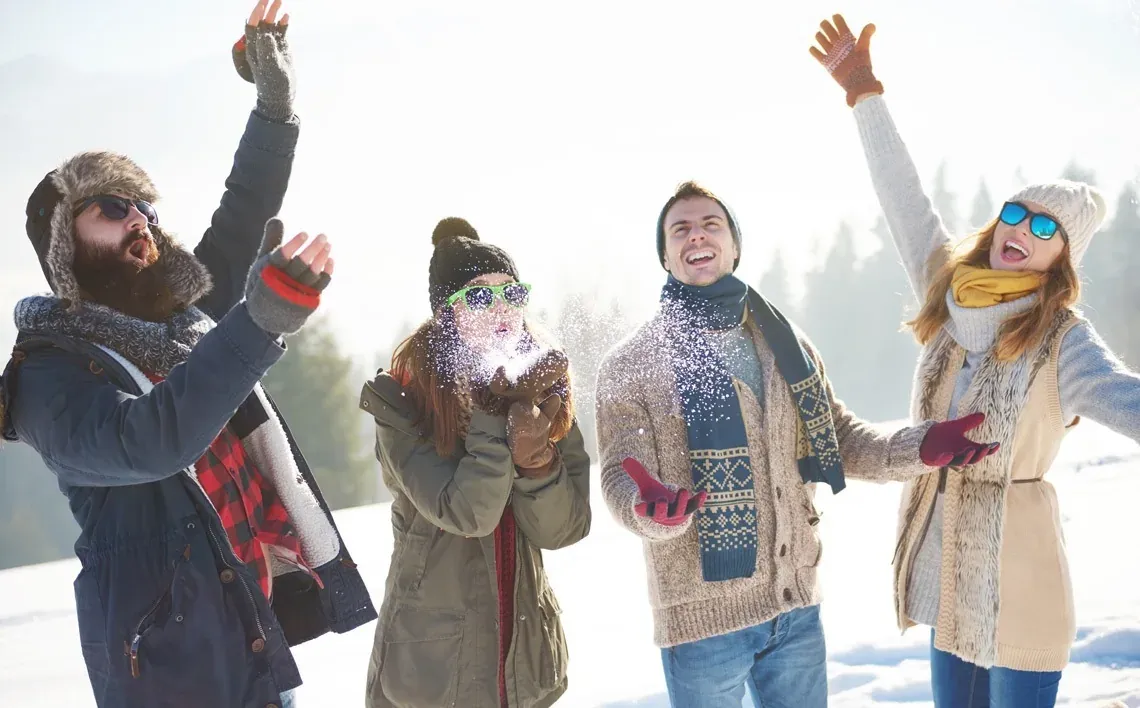NEXTA: Corporativa - Jóvenes disfrutando la nieve y celebrando en un día soleado.