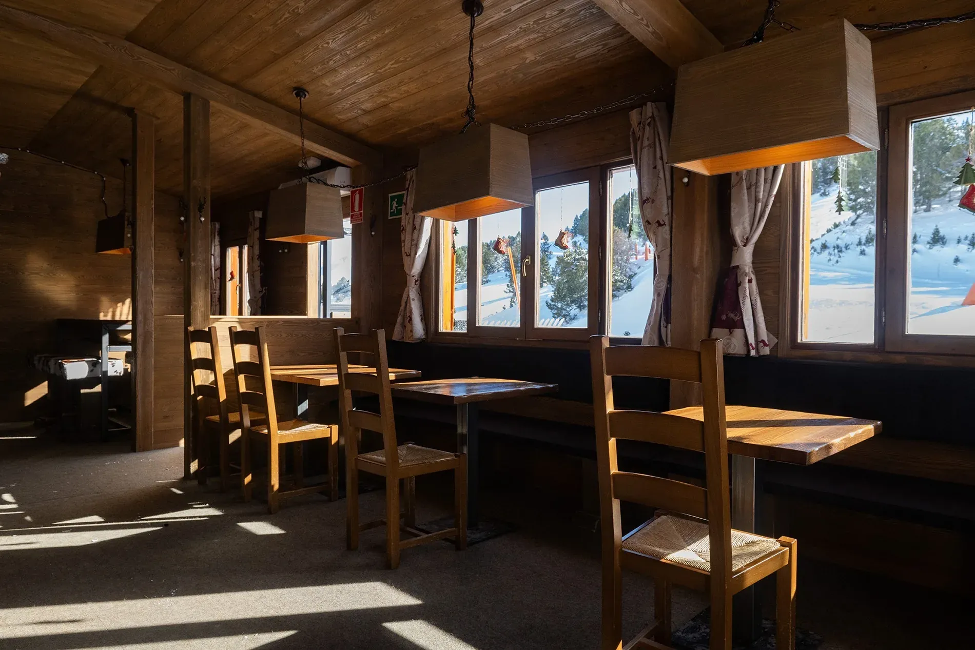 Cozy NEXTA: Corporativa hotel interior with wooden tables and chairs, snow-covered views.