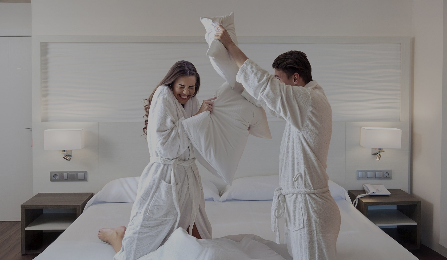 una mujer con sombrero y camisa blanca se para en un balcón de una cabaña de playa azul y blanca