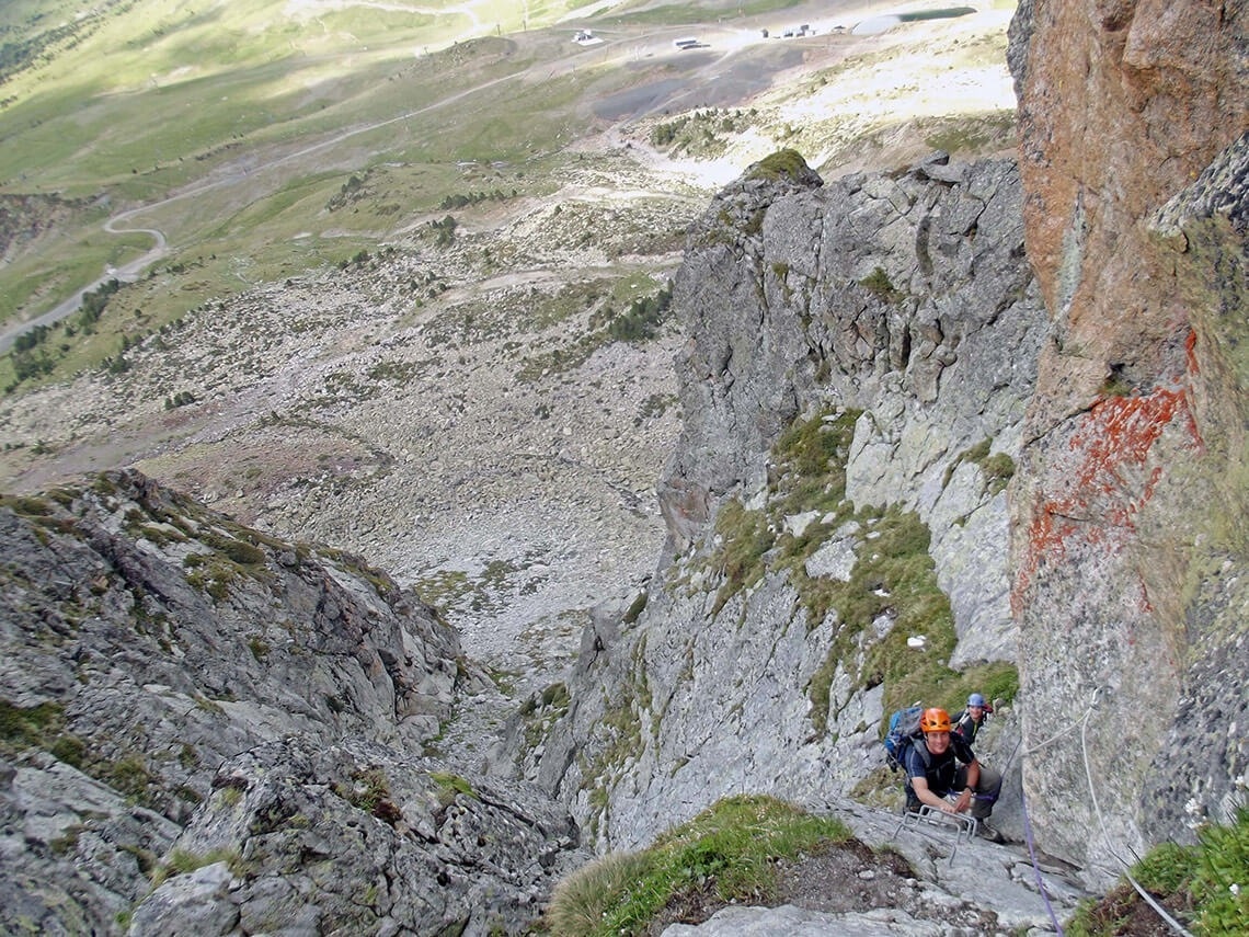 un hombre con una mochila se sienta en la ladera de una montaña