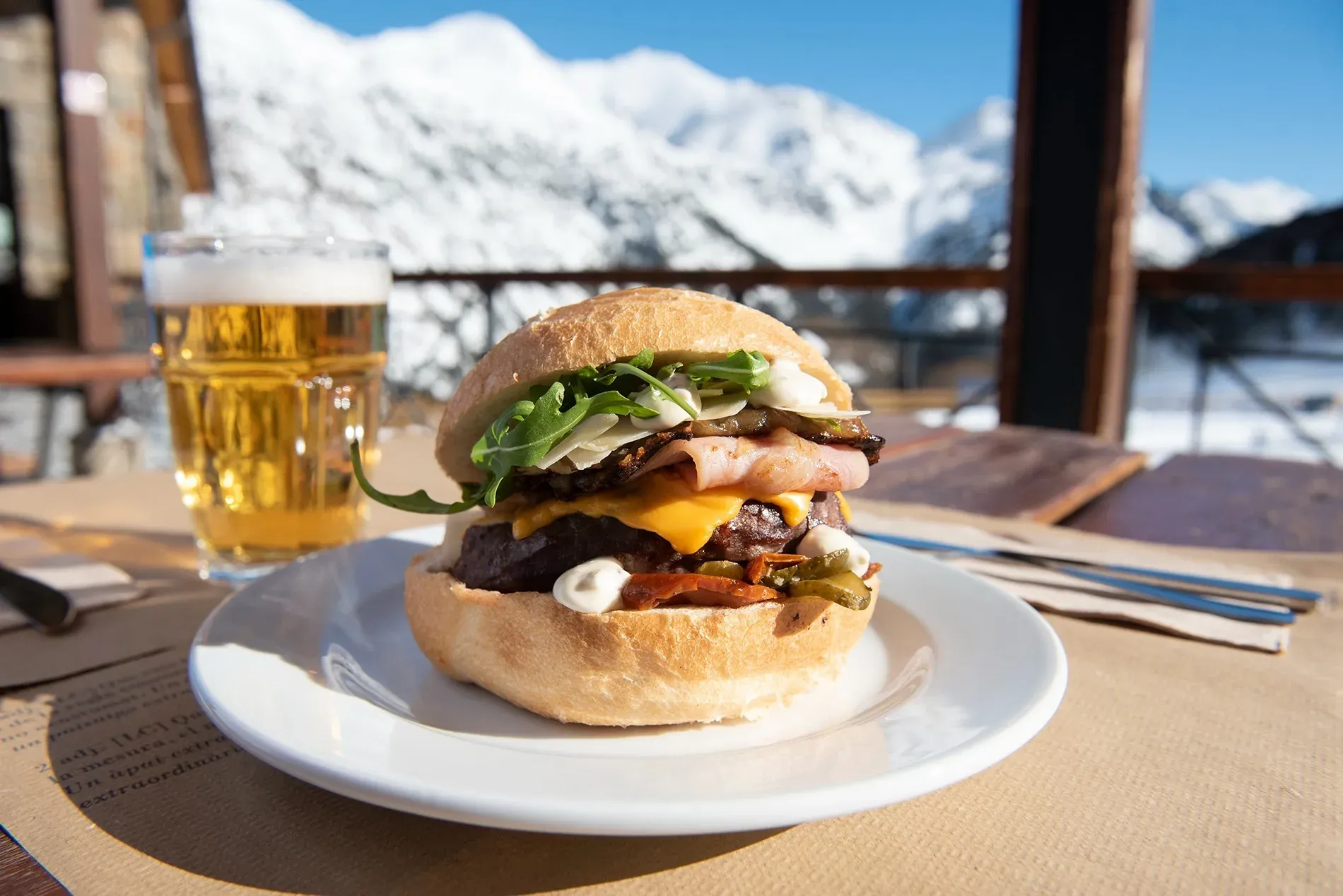 NEXTA menu: Burger and beer with mountain views.