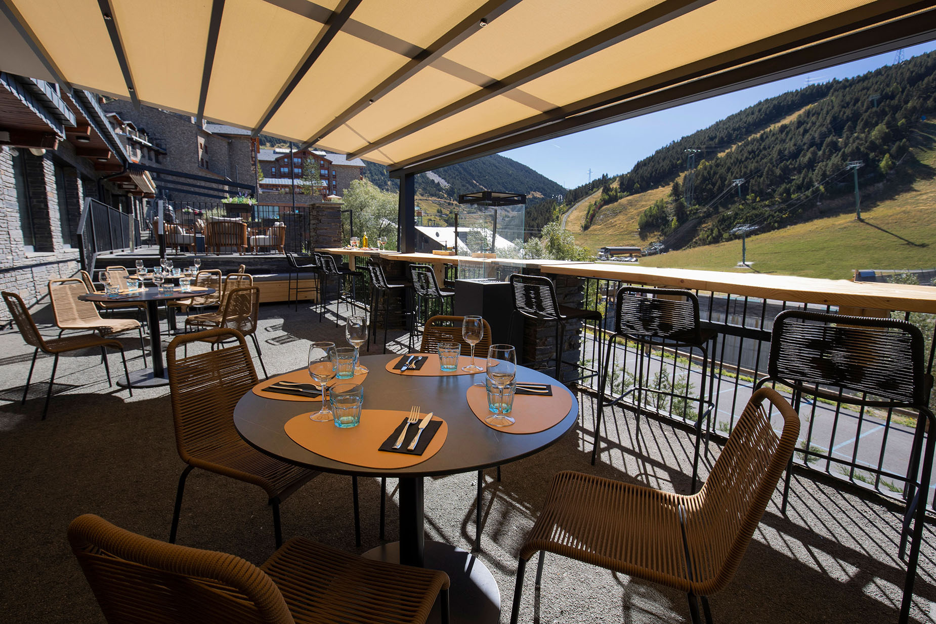 Terraza del hotel con vistaNEXTA: Corporativa a la montaña y mesas al aire libre.