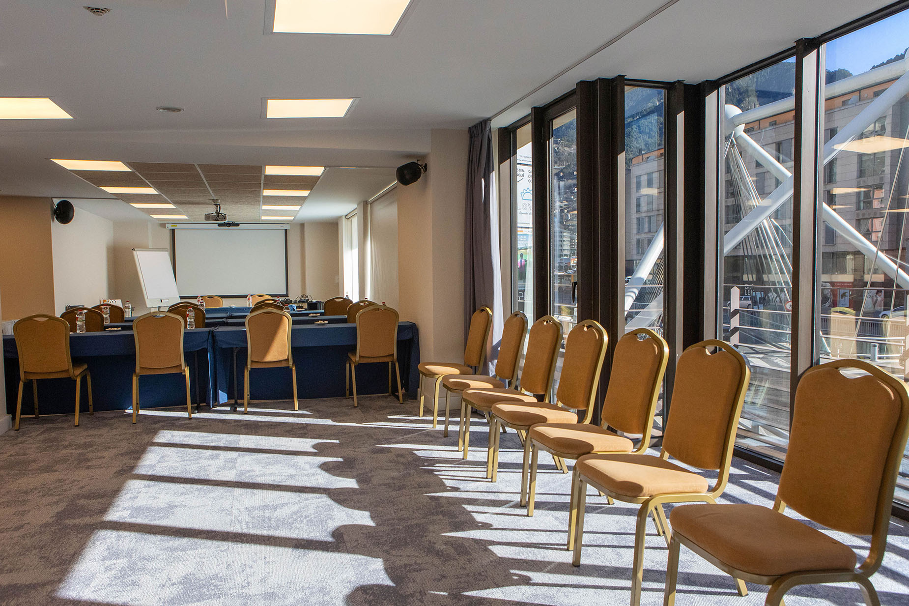 Sala de conferències amb taules i cadires preparades per a esdeveniments NEXTA: Corporativa.