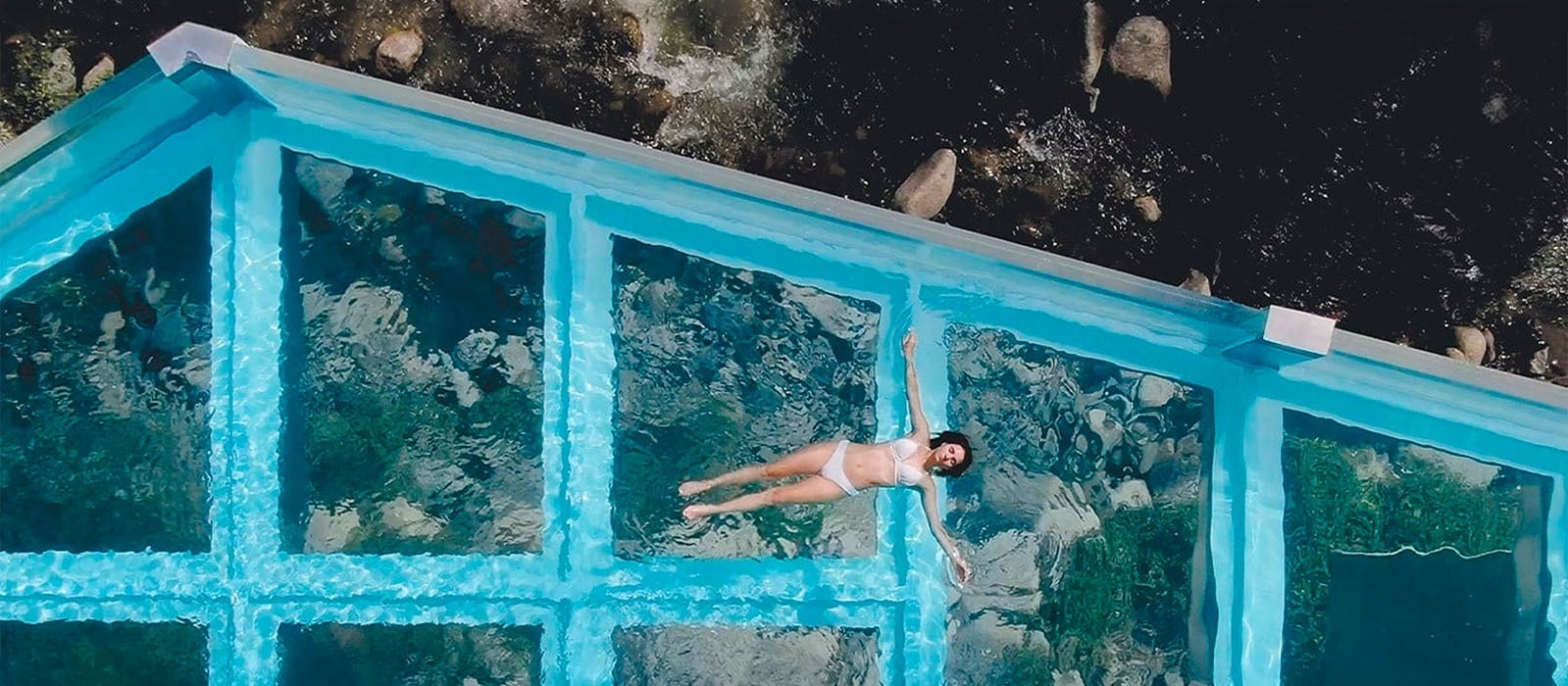 Piscina de vidre NEXTA: Corporativa amb dona flotant, vista aèria.
