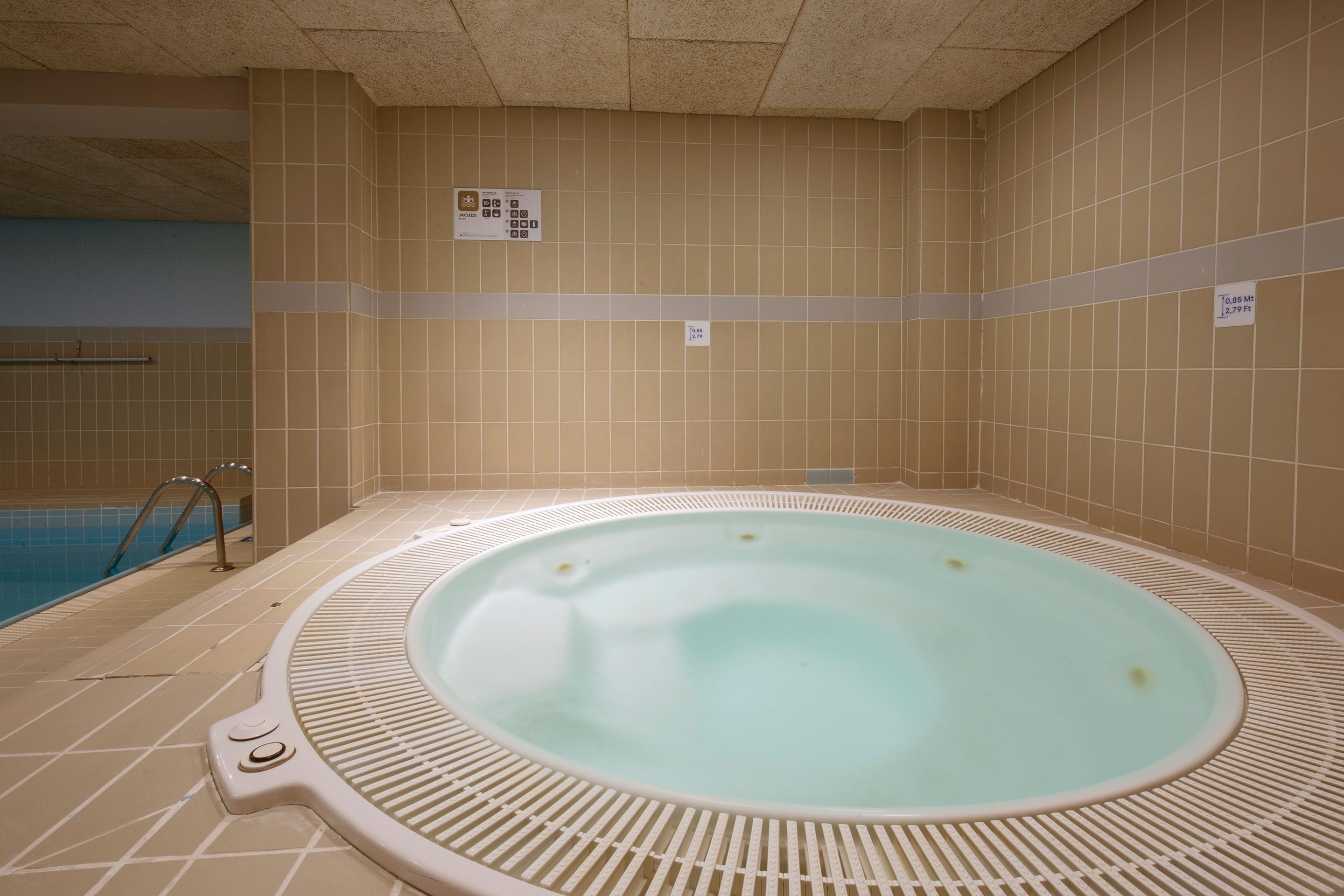 a jacuzzi in a swimming pool with a sign on the wall that says 