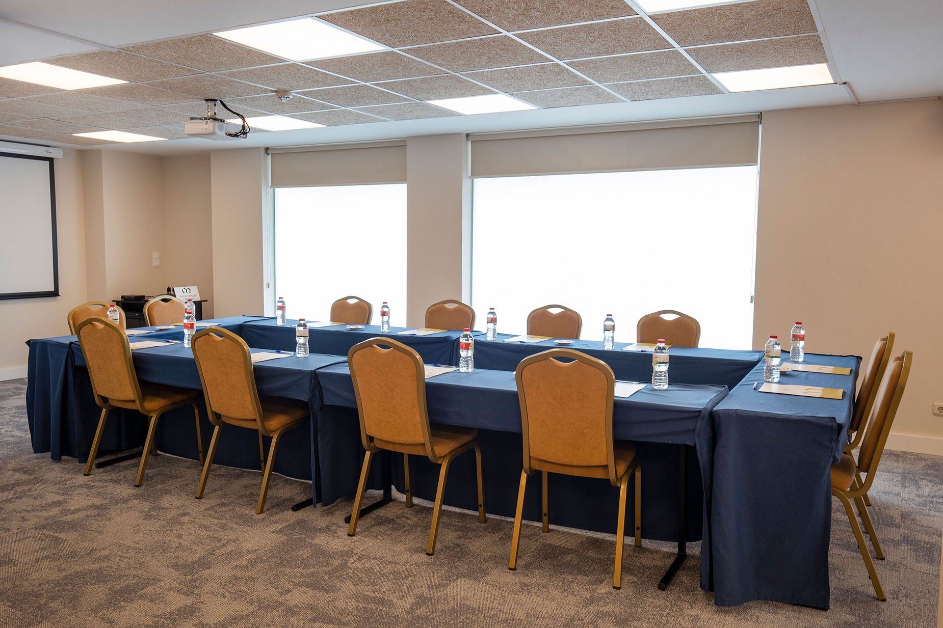 Sala de reunions amb taula en forma de U i cadires, ideal per a esdeveniments. NEXTA: Corporativa