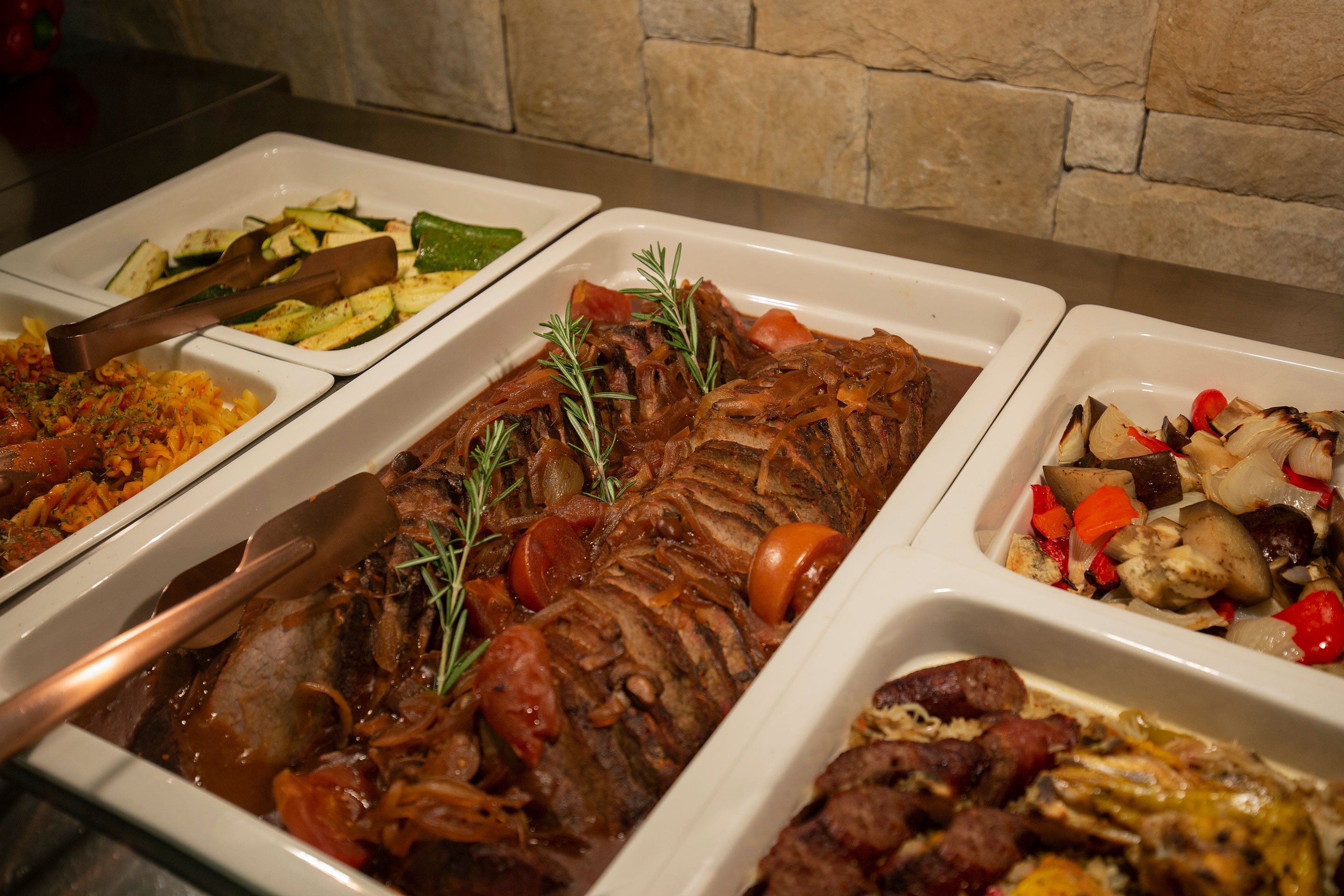 a buffet line with meat and vegetables on it