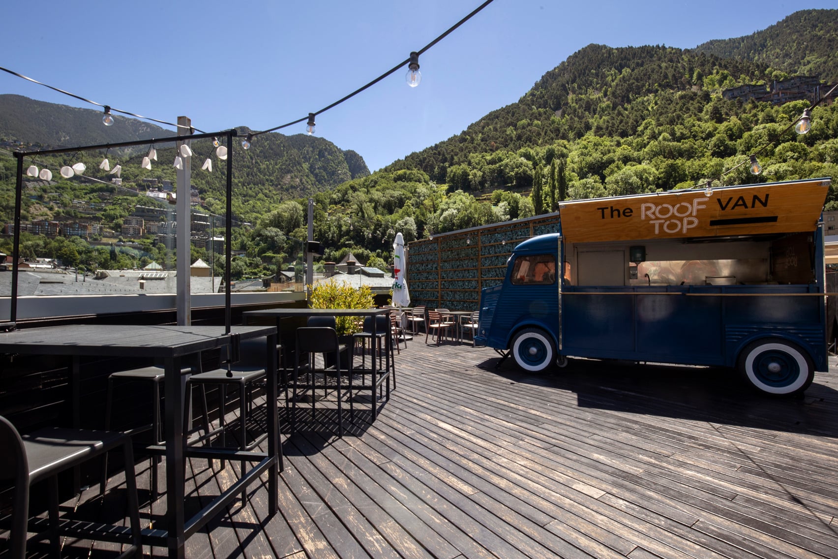 Rooftop restaurant terrace with food truck, tables and chairs, mountain views and Hotel Nexta Escaldes | Hotel 4 Estrelles a Andorra | Web Oficial.