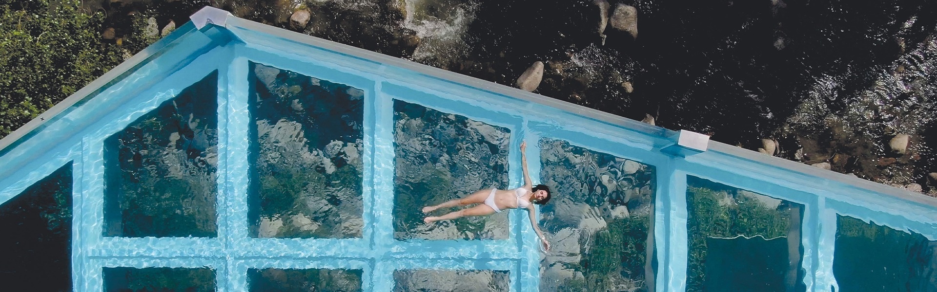 una mujer nadando en una piscina con un techo de vidrio