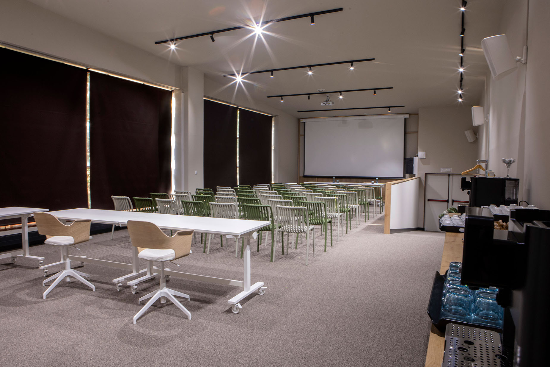 Sala de conferencias moderna en hotel con NEXTA: Corporativa, sillas y mesas, lista para eventos.
