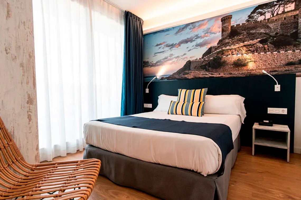 Chambre moderne NEXTA: Corporativa avec fresque de château, lit confortable et fauteuil en osier.