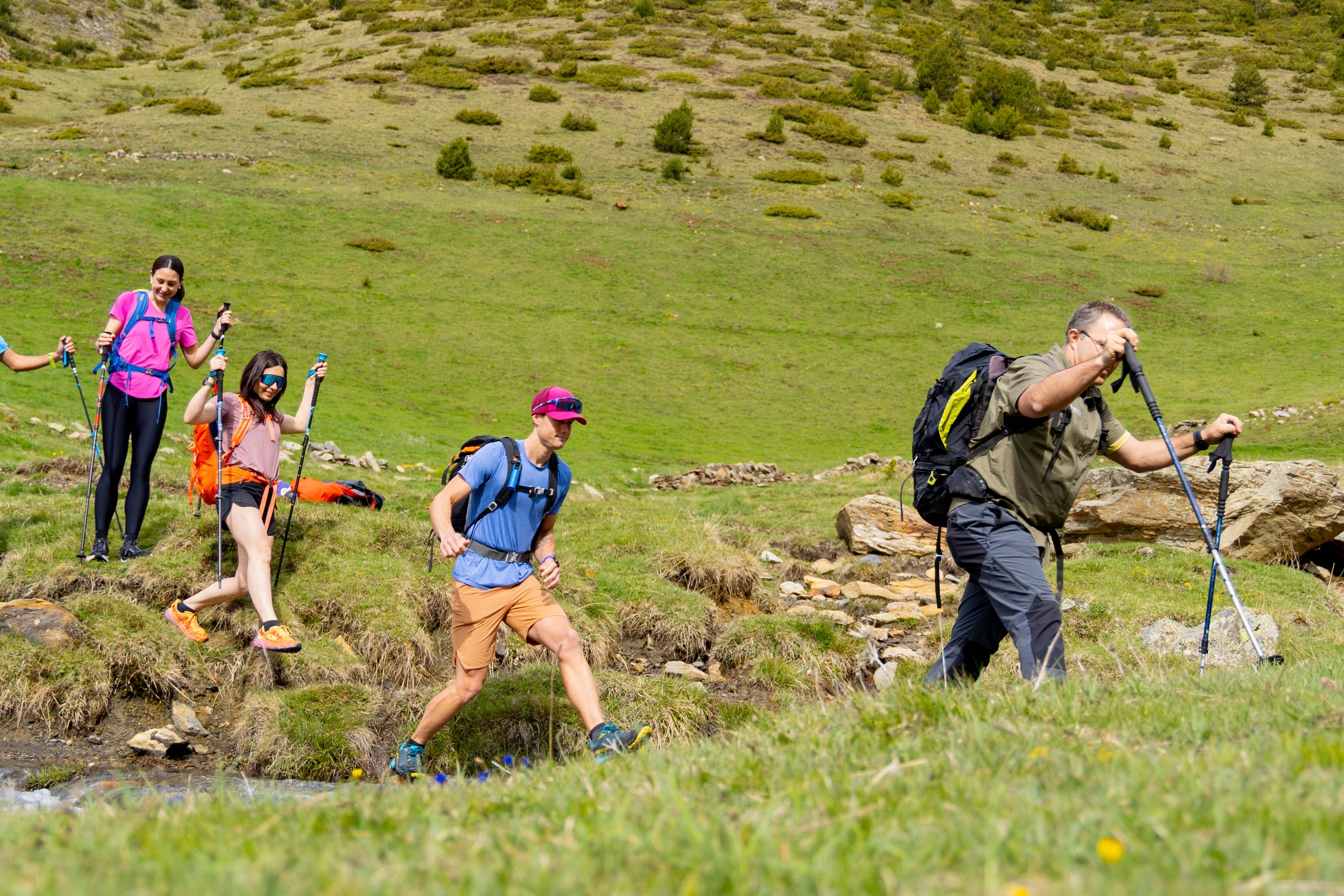 un grup de persones amb mochilas camina por un sendero