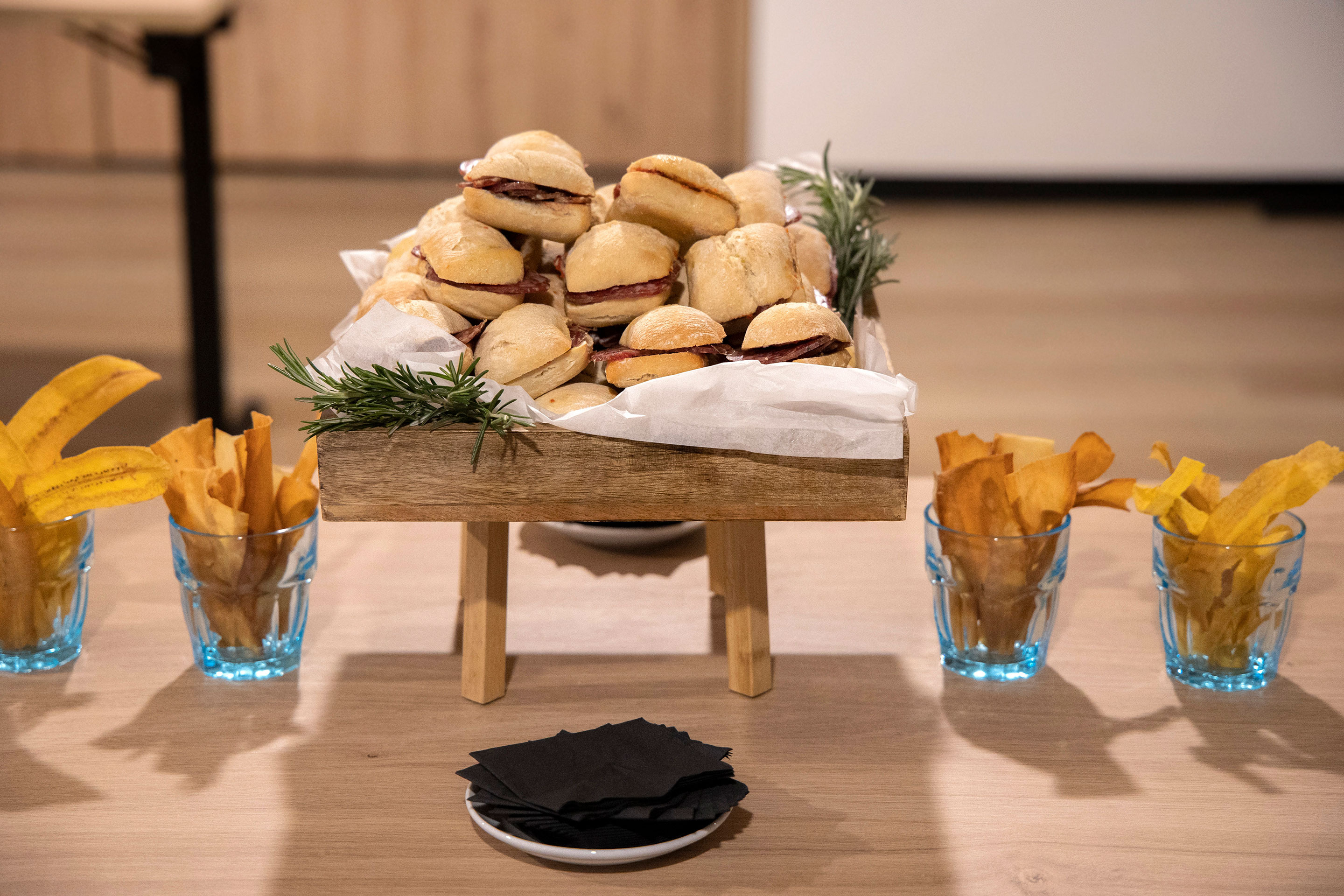 Mini-burgers et chips de banane plantain sur table en bois, parfaits pour NEXTA: Corporativa