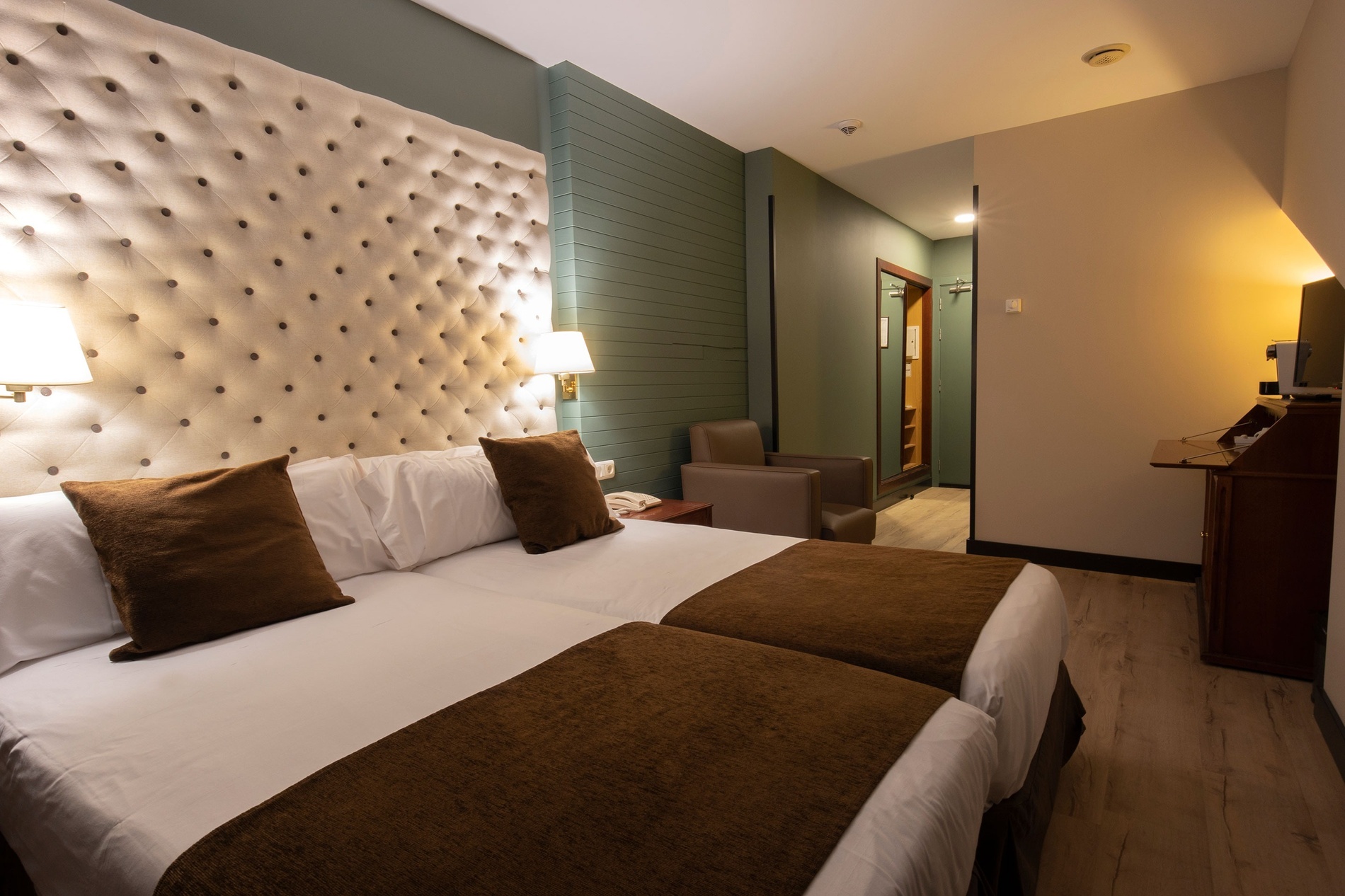 una habitación de hotel con dos camas y una silla