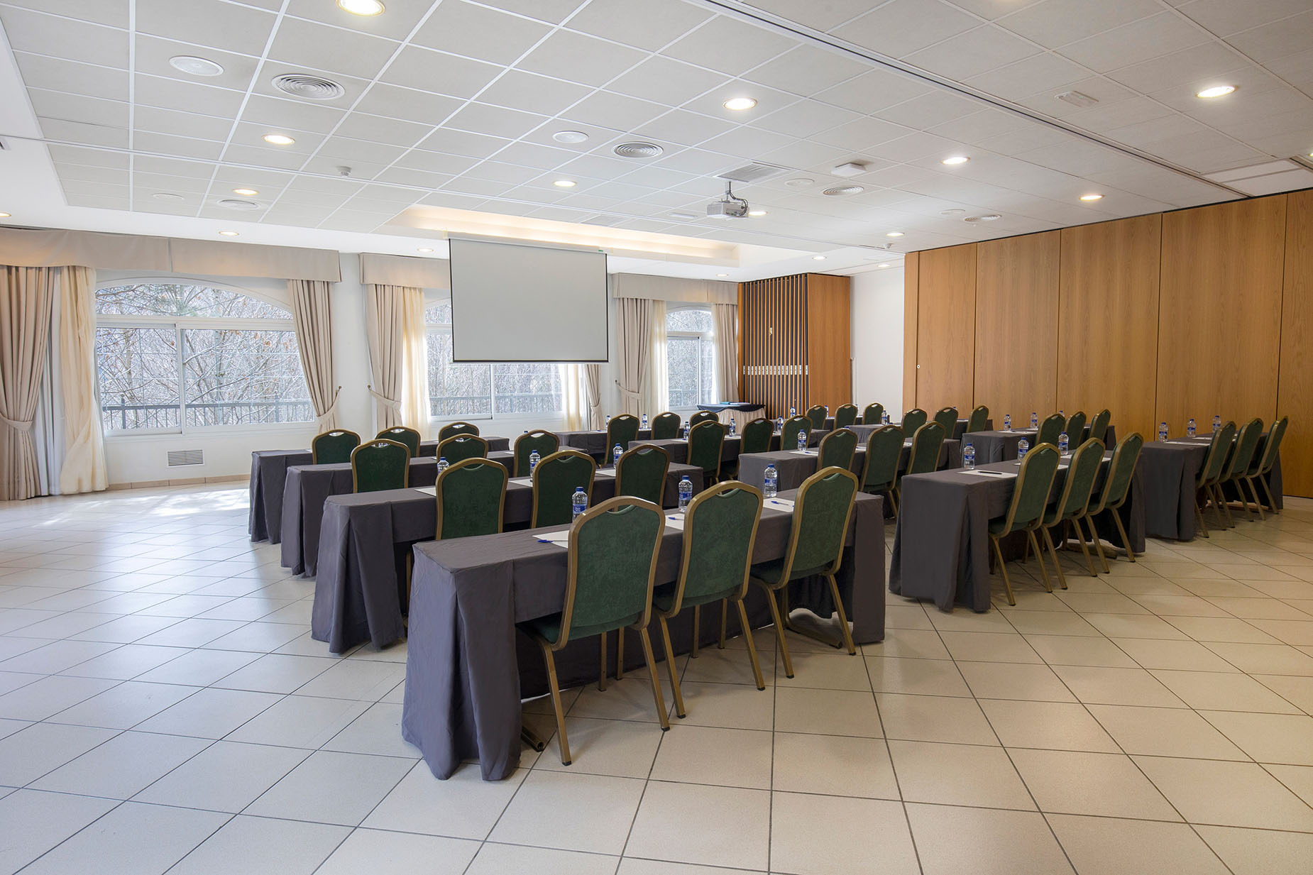 Aula de conferencias con mesas y sillas, lista para un NEXTA: Corporativa.