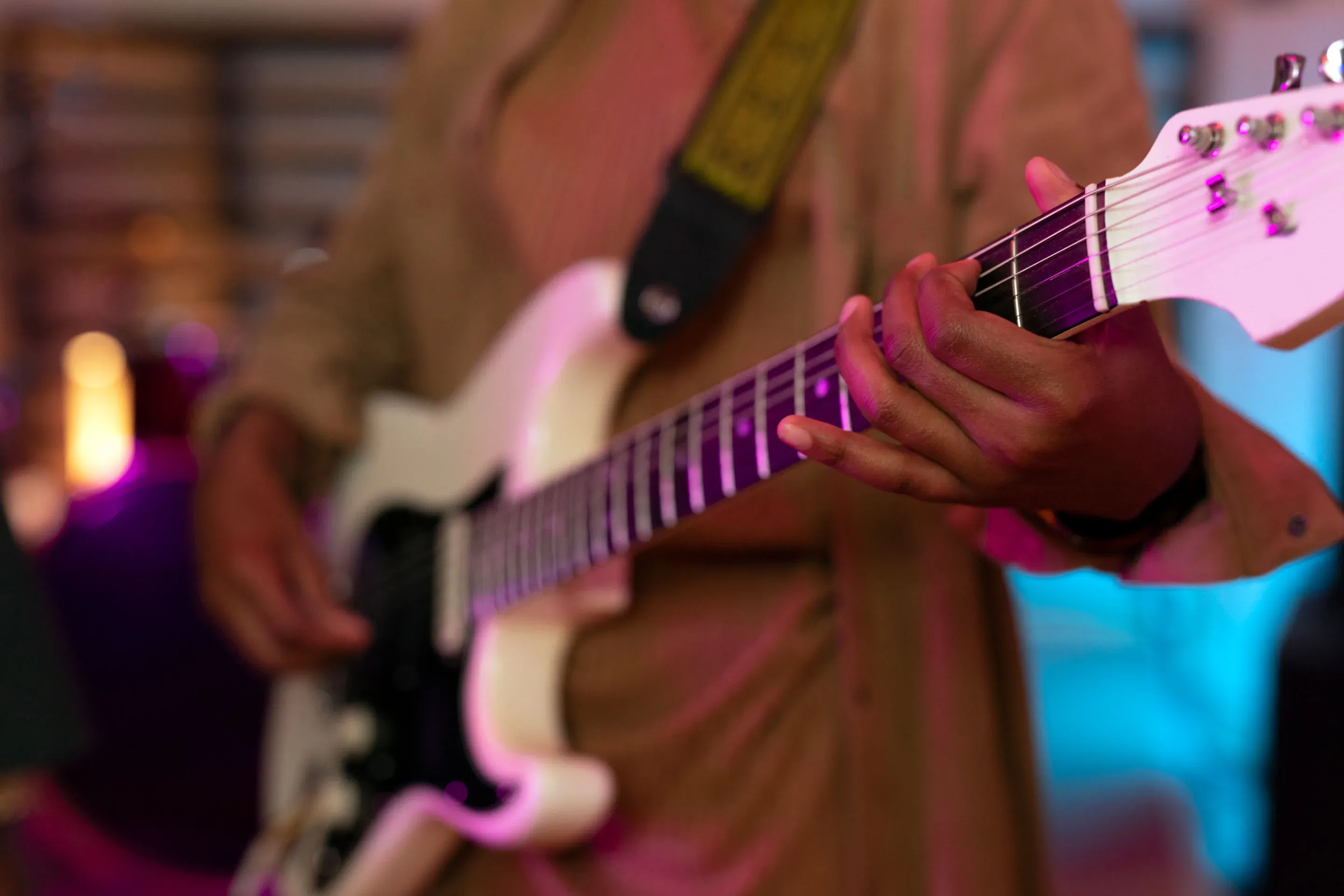 Guitarist playing at a NEXTA: Corporativa event, with colorful stage lighting.