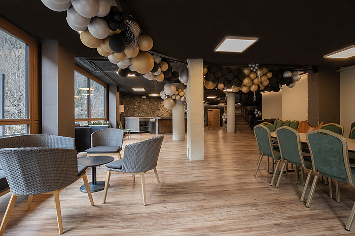 Salón de eventos decorado con globos dorados y negros, ideal para una celebración. NEXTA: Corporativa