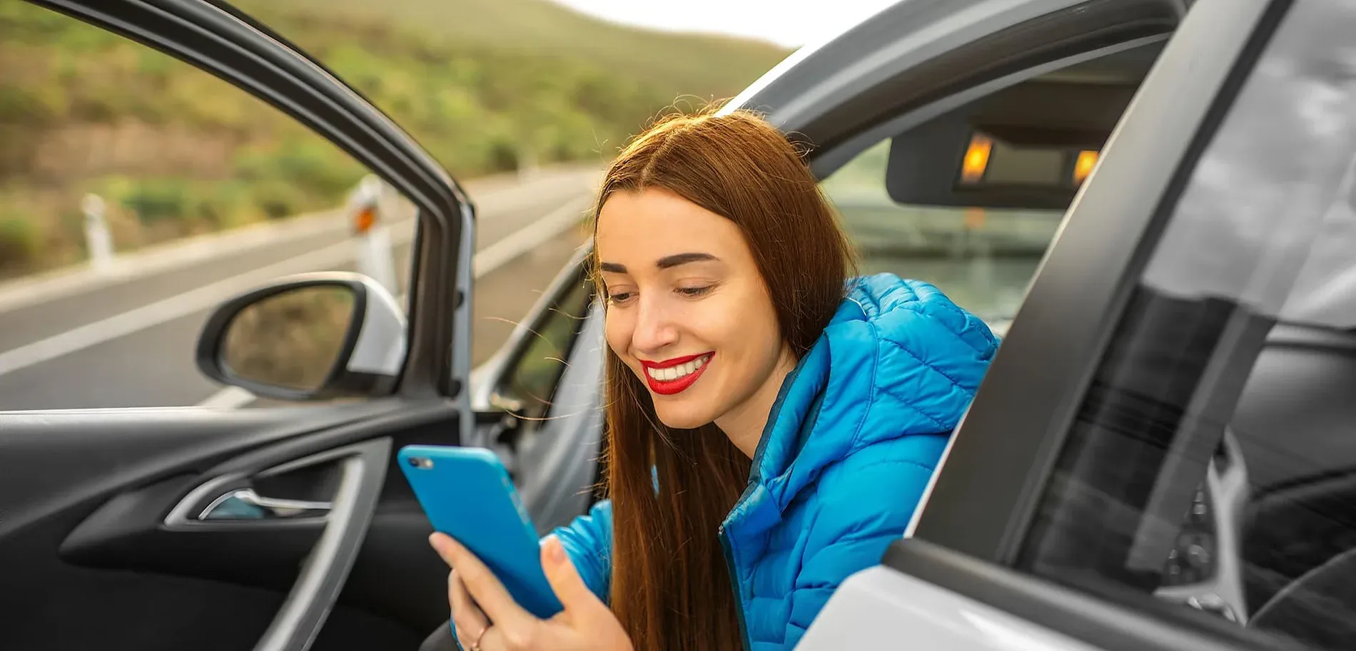 Dona somrient amb mòbil a prop de la carretera, consultant Localització i Contacte | Nexta | Andorra | Web Oficial.