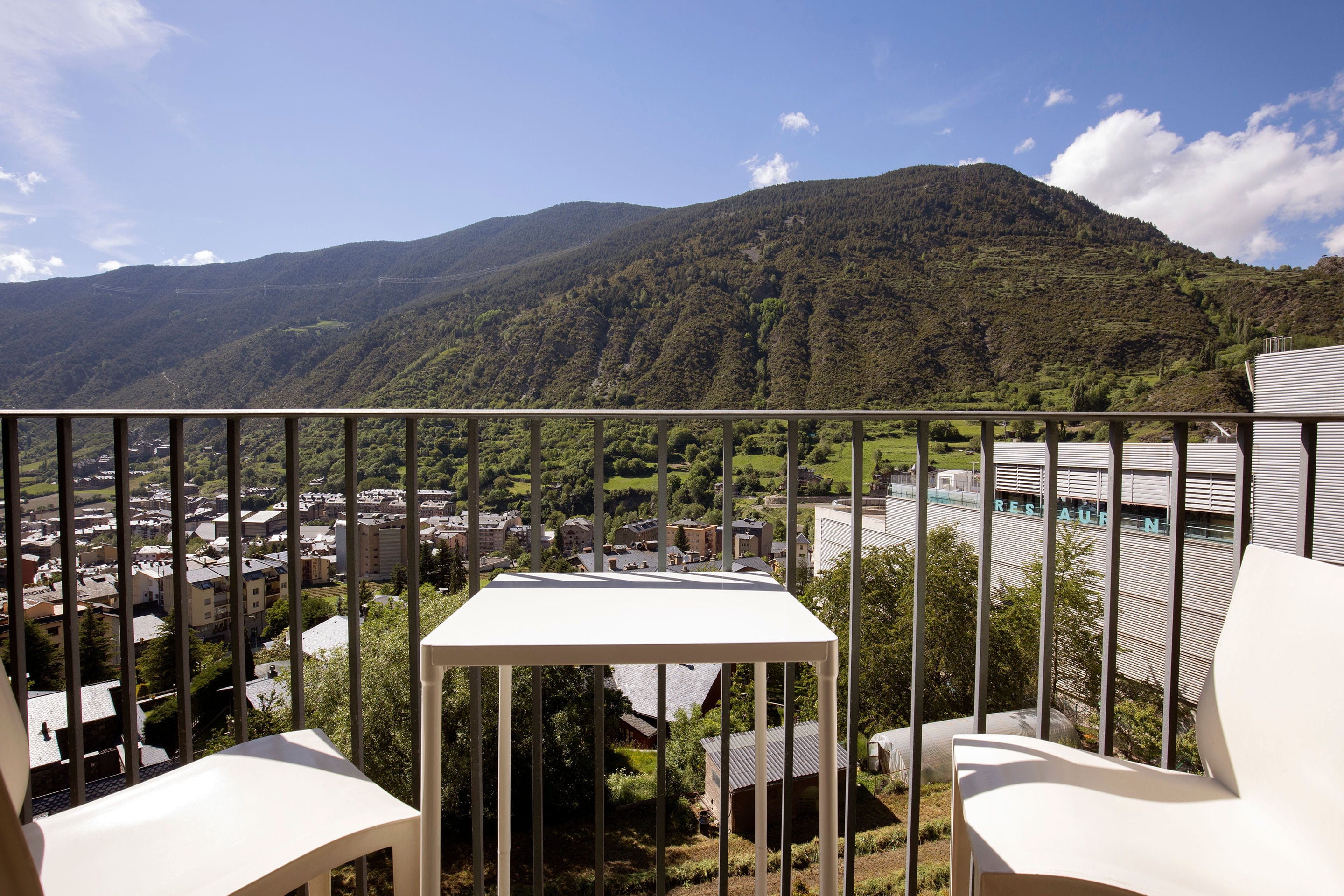 Balança amb vista a la muntanya i la ciutat, amb taula i cadires de Apartaments Shusski | Encamp | Nexta Hotels | Web Oficial.