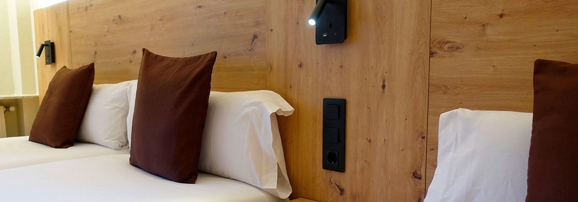 una habitació d' hotel amb una cabecera de fusta i tres llits