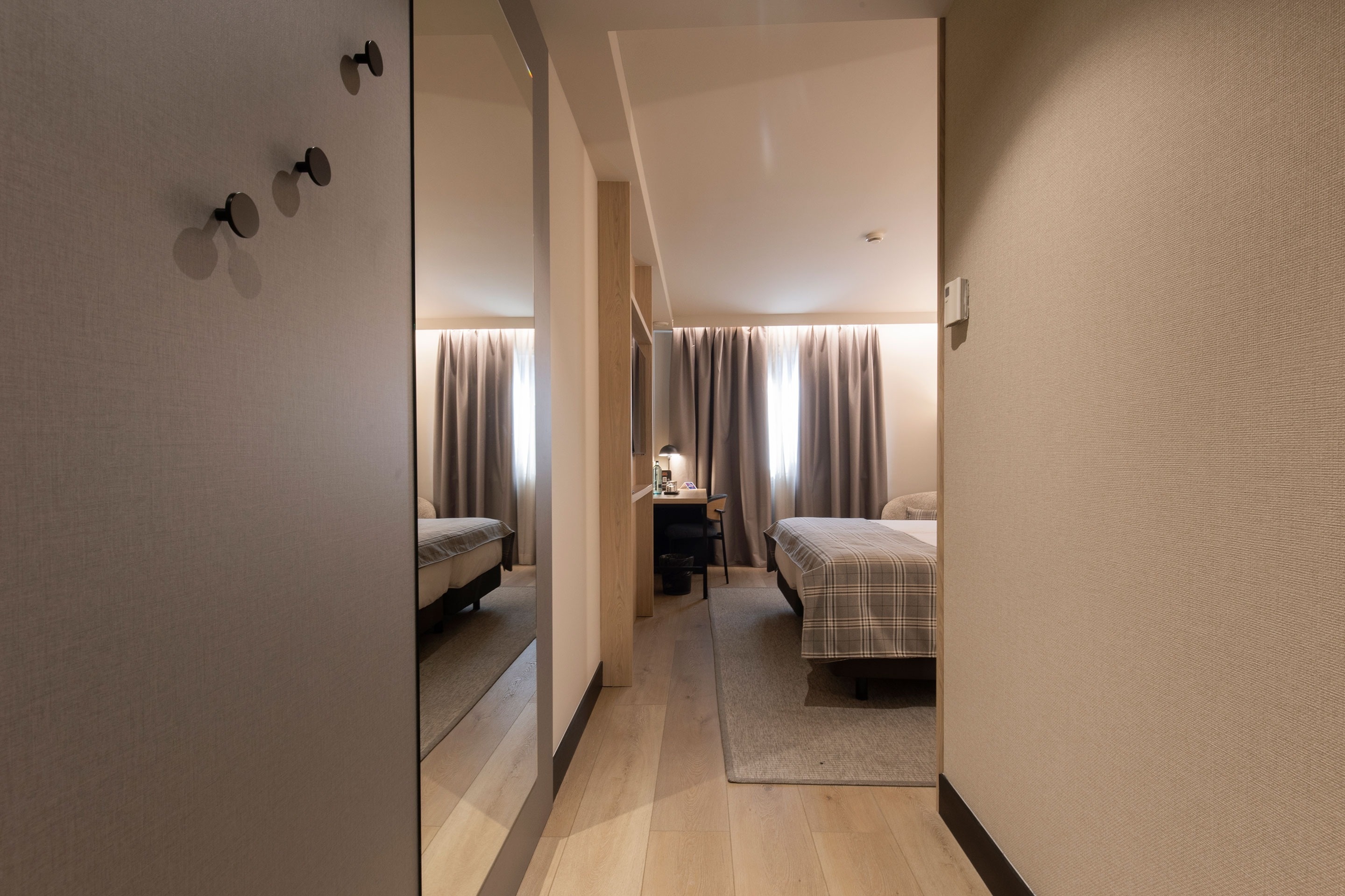 a hotel room with a bed and a desk